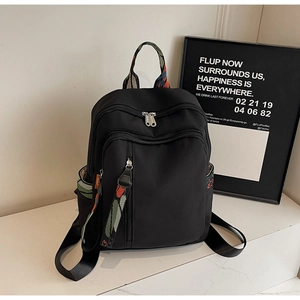 Detailed macro view of black waterproof nylon backpack with colorful jacquard webbing and zipper