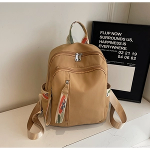 Close-up of khaki nylon backpack featuring ethnic pattern jacquard webbing detail