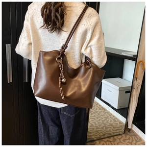 Deep brown large tote bag with knotted handles shown from back perspective on model
