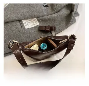 Macro detail of dark brown hobo bag interior with zip, showing daily storage capacity