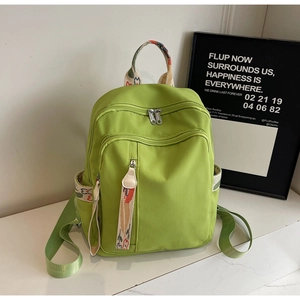 Detail of green backpack featuring vibrant bohemian woven patterns and multi-zipper pockets