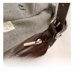 Detailed macro view of retro brown oil wax leather bag with silver metal zipper buckle