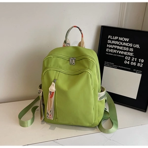 Detail of vibrant green backpack featuring ethnic print straps and durable zipper pockets