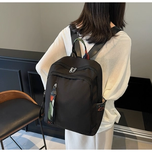 Close-up of black travel backpack featuring ethnic embroidery and multiple zip pockets