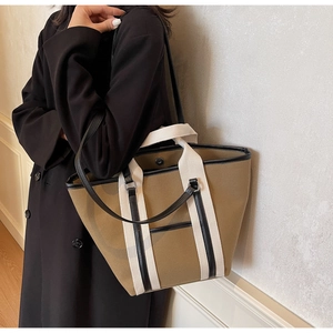 Detail of canvas tote bag with leather trim and metallic snap button closure