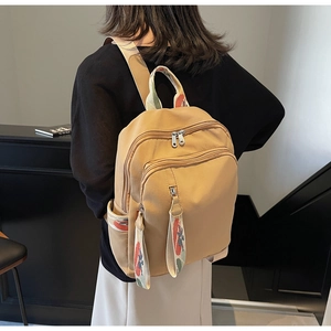 Detail of khaki backpack with colorful embroidered straps and large compartments