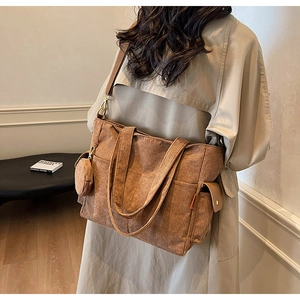 Brown corduroy tote bag detail with side pocket and small round pouch in home setting