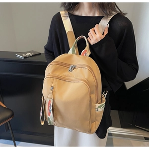 Detail of khaki backpack with rainbow geometric jacquard webbing and side pockets