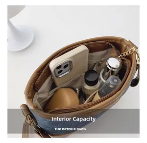 Internal capacity of denim and leather bucket bag showing compartments for daily items
