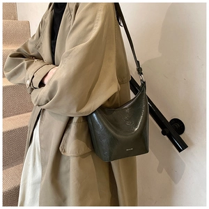 Detail of vintage green oil wax leather bucket bag with NO FILTRE text and silver buckle