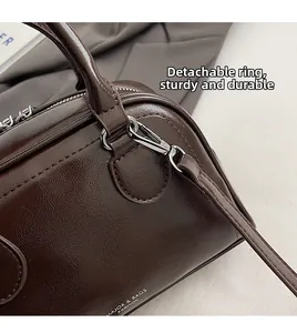 Detailansicht der silbernen Metallhaken und Lederstruktur dieser braunen Tasche