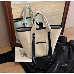 Detail of canvas tote bag with contrast black trim and dual strap handle system