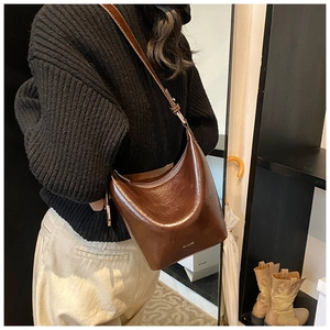 Detailed view of dark brown glossy leather hobo bag with subtle NO FILTER branding