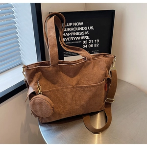 Detailed macro view of the brown corduroy tote texture and mini coin purse attachment