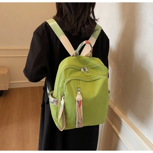 Detail view of avocado green travel backpack with floral printed straps and side pockets