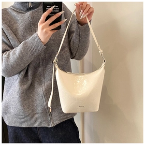 Close-up of cream white bucket bag with pleated texture and NO FILTER text detail