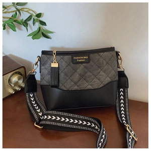 Detail of luxury quilted bucket bag with golden hardware and arrow patterned strap