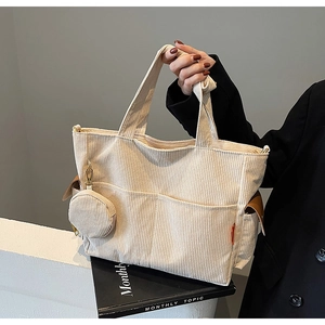 Close-up of beige corduroy tote bag showing large capacity and soft textured fabric