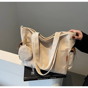 Detail of cream corduroy tote bag featuring a front pocket and matching round coin purse