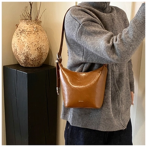 Close-up of vintage brown glossy leather underarm bag with NO FILTER logo print