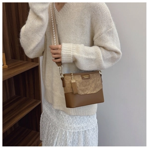 Brown quilted crossbody bag with stylish wide strap shown on model in warm home setting