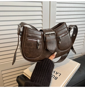 Detail view of brown vintage PU leather shoulder bag with decorative silver buckle