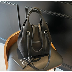 Detail of canvas tote bag with leather trim, silver hardware and adjustable strap