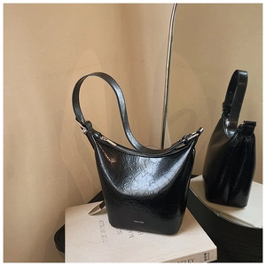 Detail of black glossy hobo bag with wrinkled texture and silver zipper detail