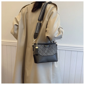 Quilted crossbody bucket bag with grey contrast fabric and geometric strap detail