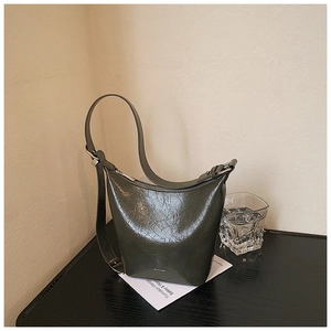 Detail of dark green crescent hobo bag with vintage crinkled texture and silver zipper