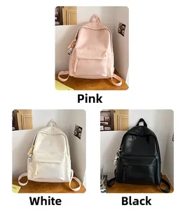 Detailed close-up of solid color backpacks in pink, white, and black with astronaut charm