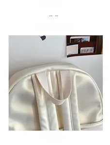 Detail view of the durable top handle and woven straps on a pearl white casual backpack