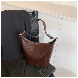 Detail of vintage chocolate brown leather hobo bag with oil-wax texture and metal zipper