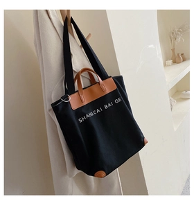 Detail of vintage canvas tote bag with brown leather handles and shoulder strap