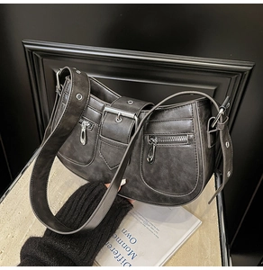 Detail of dark grey retro shoulder bag with silver hardware and distressed leather texture