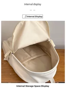 Internal view of minimalist beige backpack showing multi-layer compartments and zippers