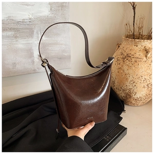 Detail of vintage brown bucket bag with shiny cracked texture and NO FILTER slogan