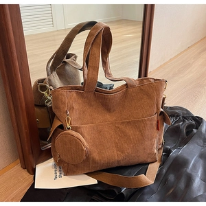 Detail of brown corduroy tote bag with mini round coin purse and textured vertical ribs