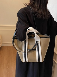 Minimalist khaki canvas tote bag for women with white handles and black leather trim