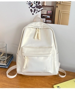 Close-up of cream leather backpack featuring woven rope zippers and Hoog logo detail
