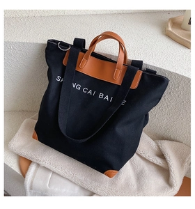 Detail view of large canvas tote bag with reinforced brown leather corners and carry handles