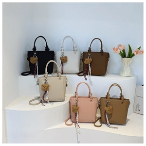 Collection of six litchi texture bucket bags in various colors with bear charms