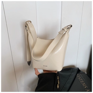 Detailed shot of cream bucket bag featuring NO FILTER print and adjustable strap