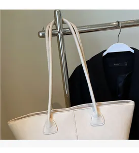 Detail view of cream tote bag with fine leather texture and durable long handles