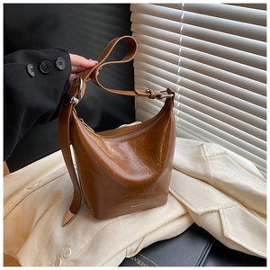 Detail of vintage brown leather bucket bag with silver buckle and embossed logo