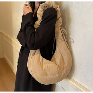 Detail of a large khaki nylon crescent bag featuring a unique ruched ruffled shoulder strap