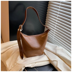 Detail of vintage brown oil-wax leather bucket bag with silver zipper and NOFILTER brand text