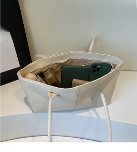 Spacious interior of off-white tote bag showing storage for phone and umbrella