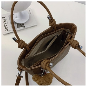 Brown litchi leather tote bag with knotted handle and interior zipper pocket detail