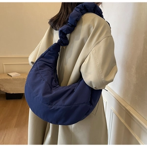 Macro shot of navy blue quilted nylon fabric and ruched cloud shoulder strap detail
